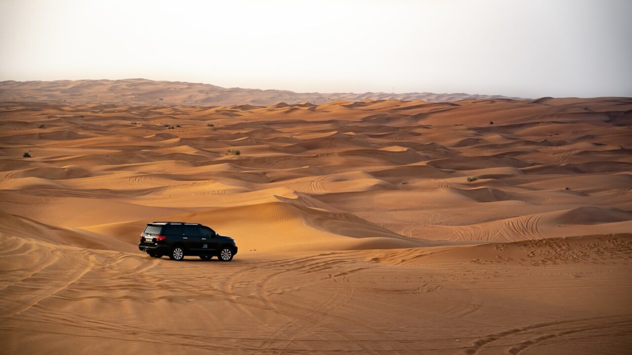 Vehicle driving over dunes in the Dubai desert
