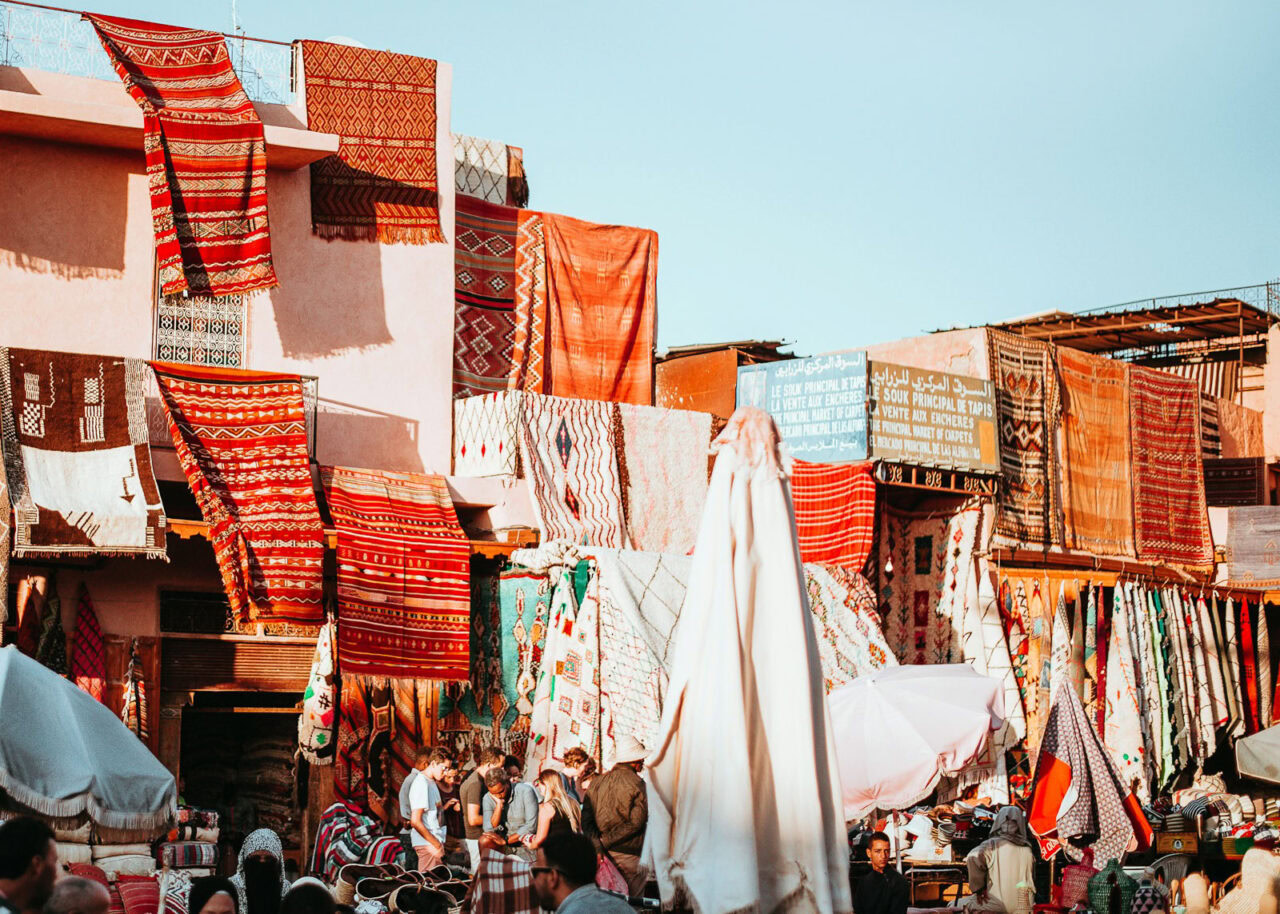 Moroccan rugs hanging from a building in a souk