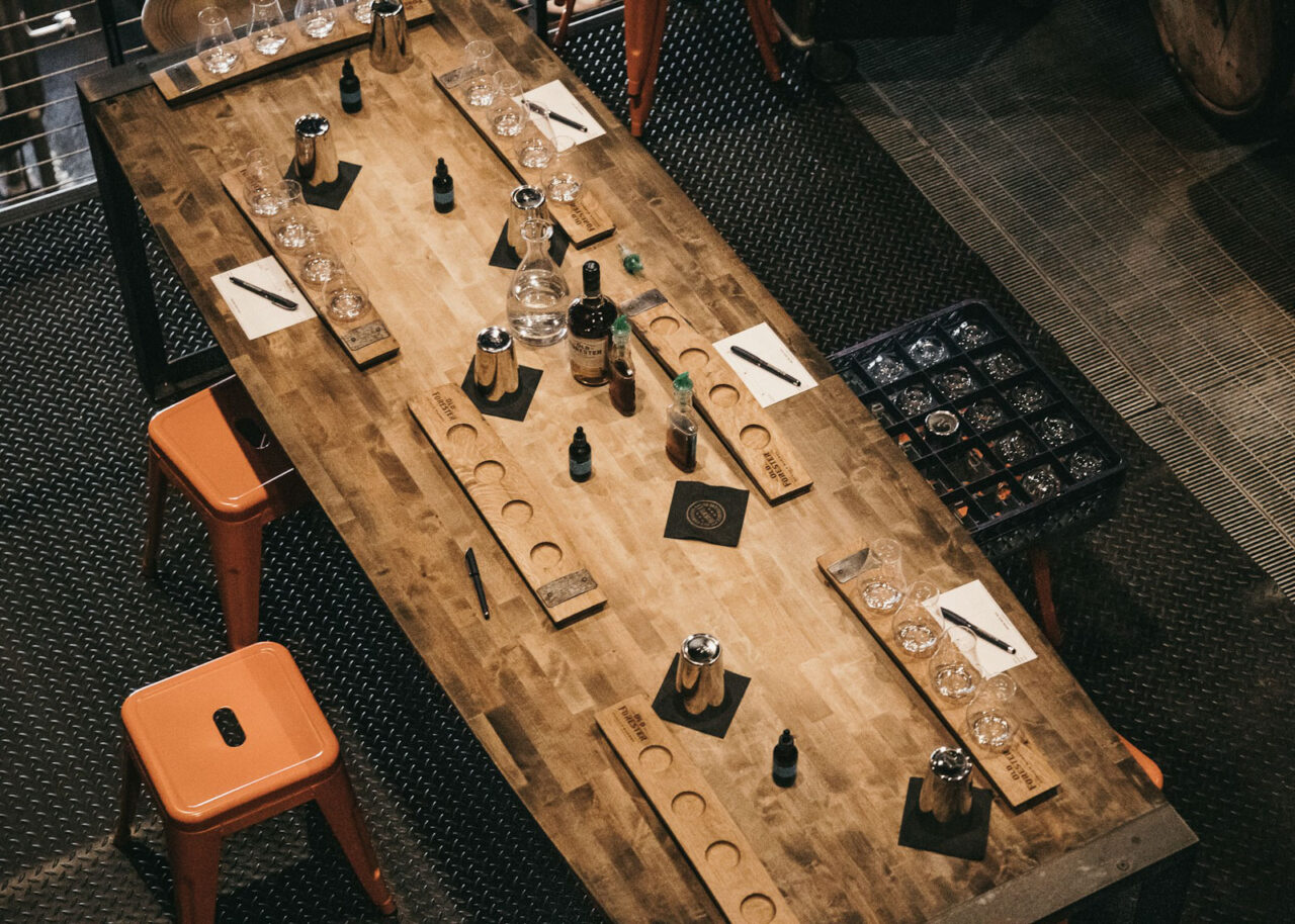 Long table with whiskey bottles and glasses for tasting on the Kentucky Bourbon Trail