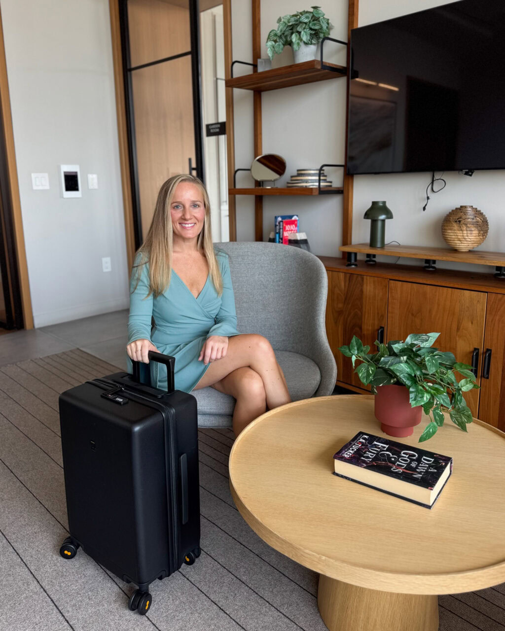 Woman sitting on a chair in a blue dress with Level8 textured carry on