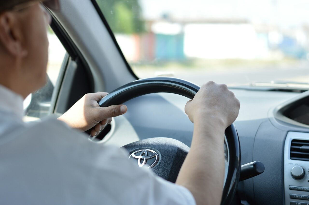 Close up of a man holding a Toyota steering wheel