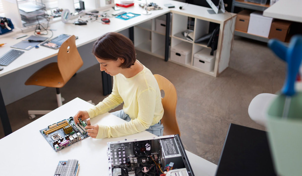 Woman assembling computer motherboard in workshop
